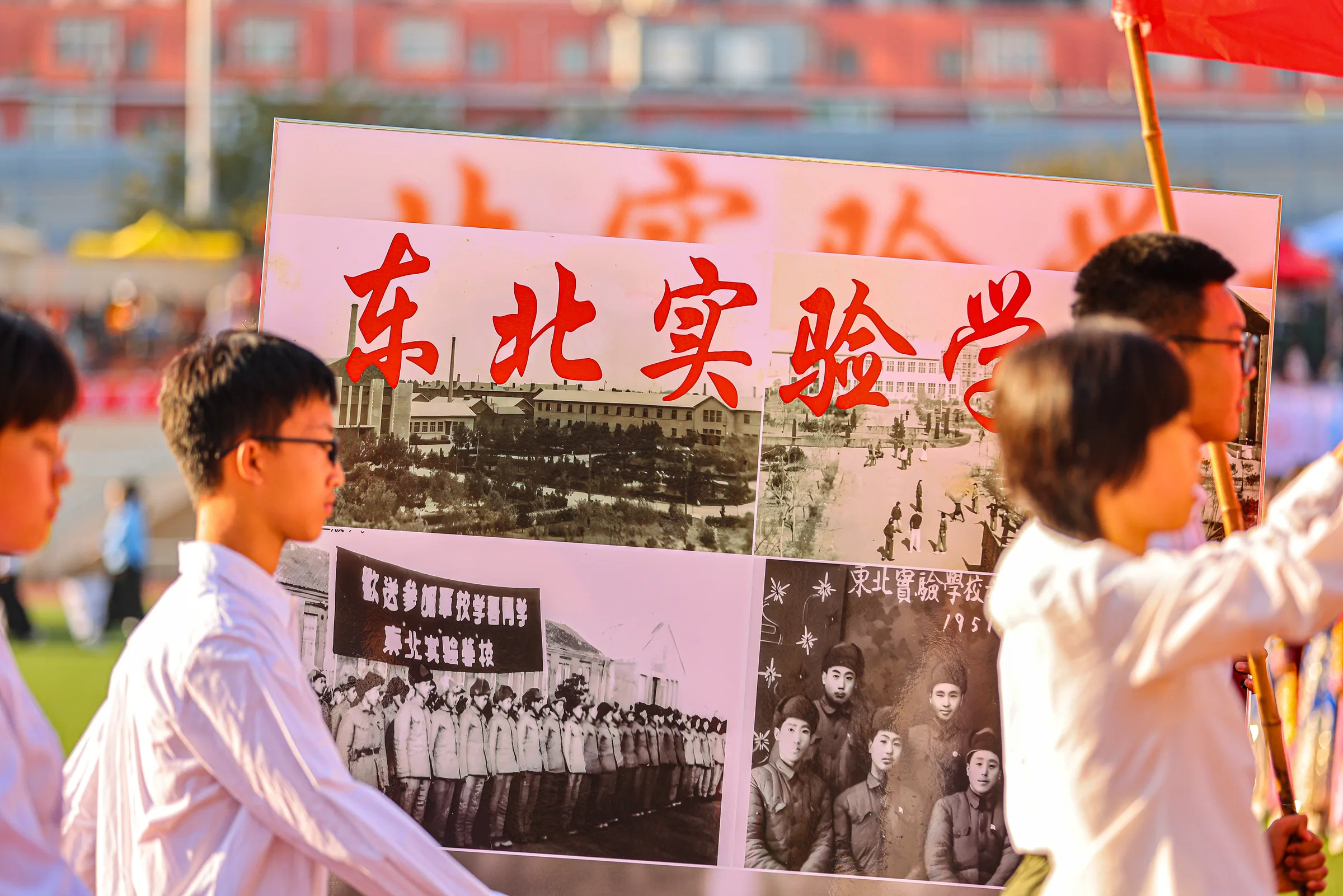 两个人站在展板前展示老照片与说明文字