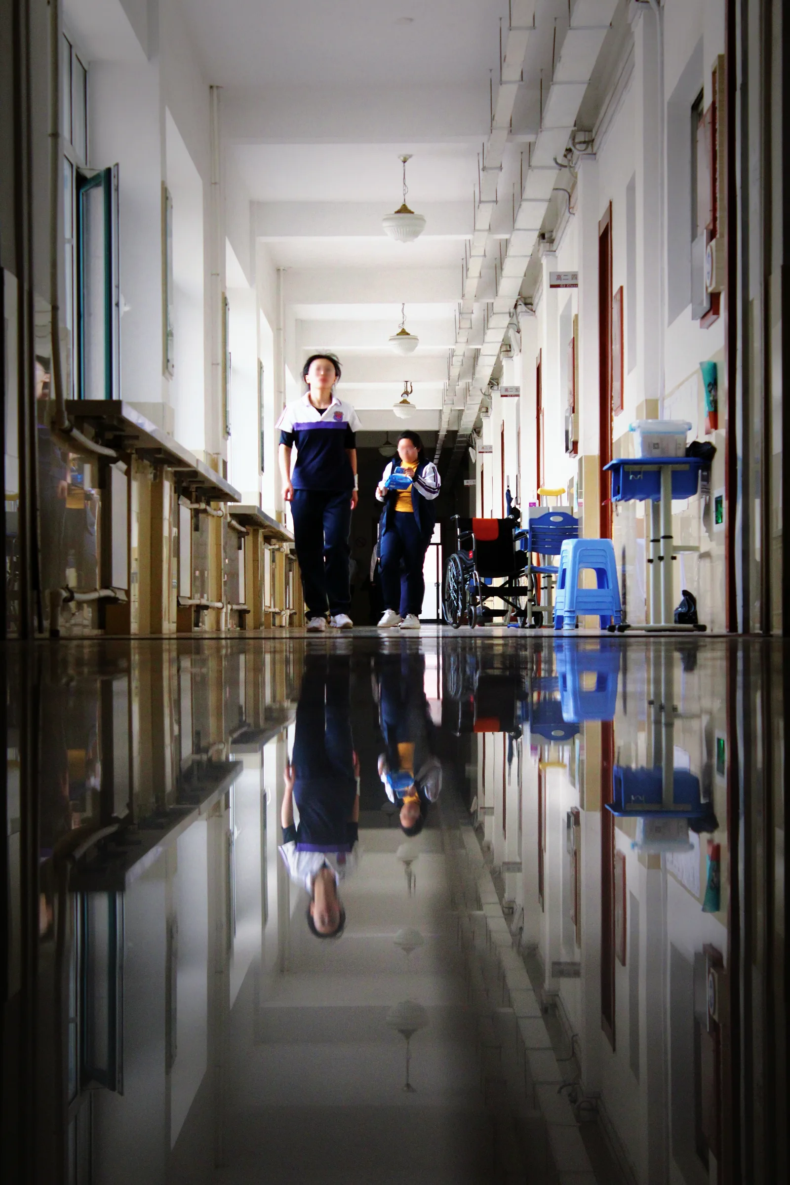 贴地拍摄的主教学楼走廊，光滑地砖映出上下对称的倒影