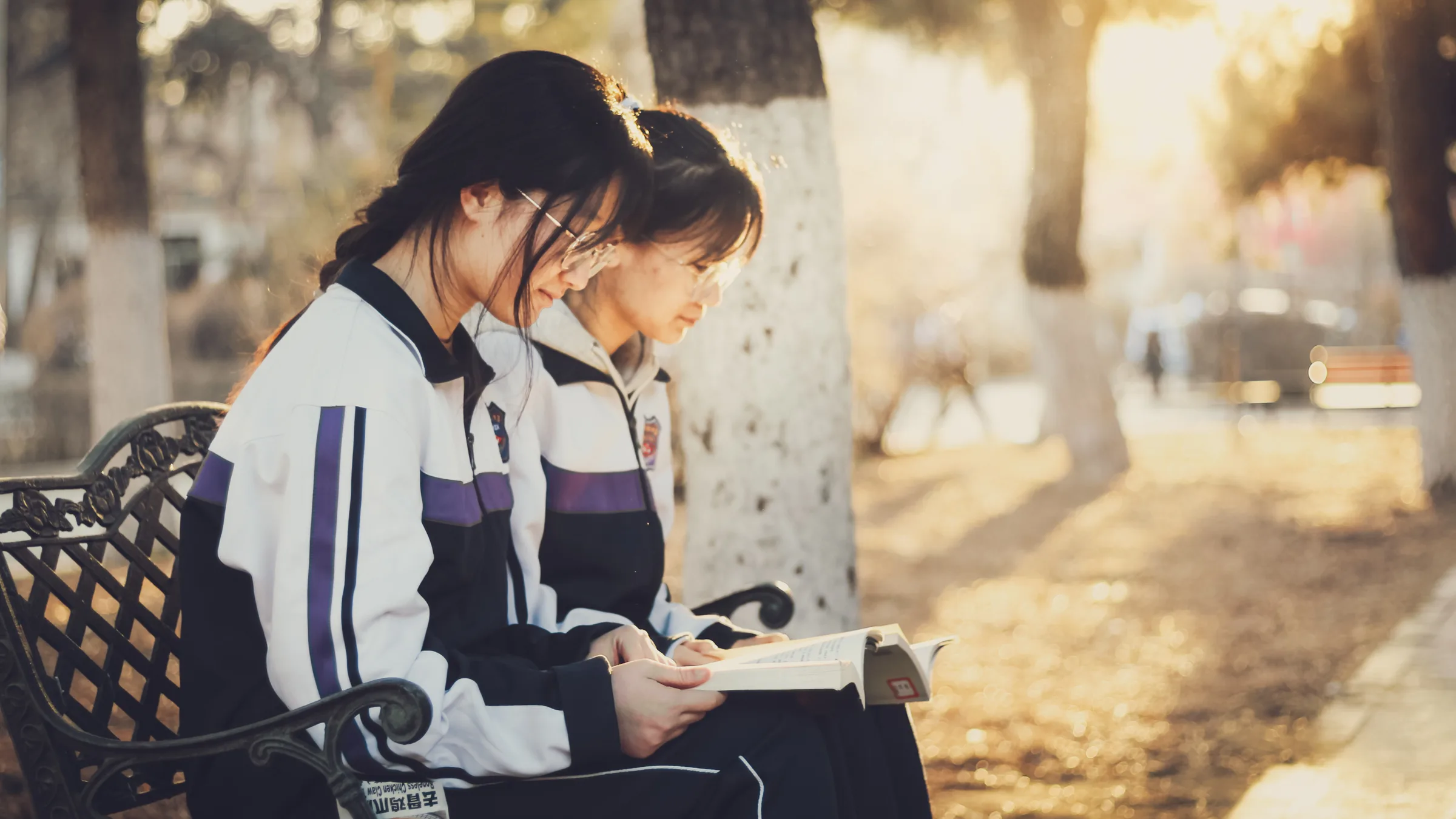 一位女生在暖色逆光里低头看书或记录