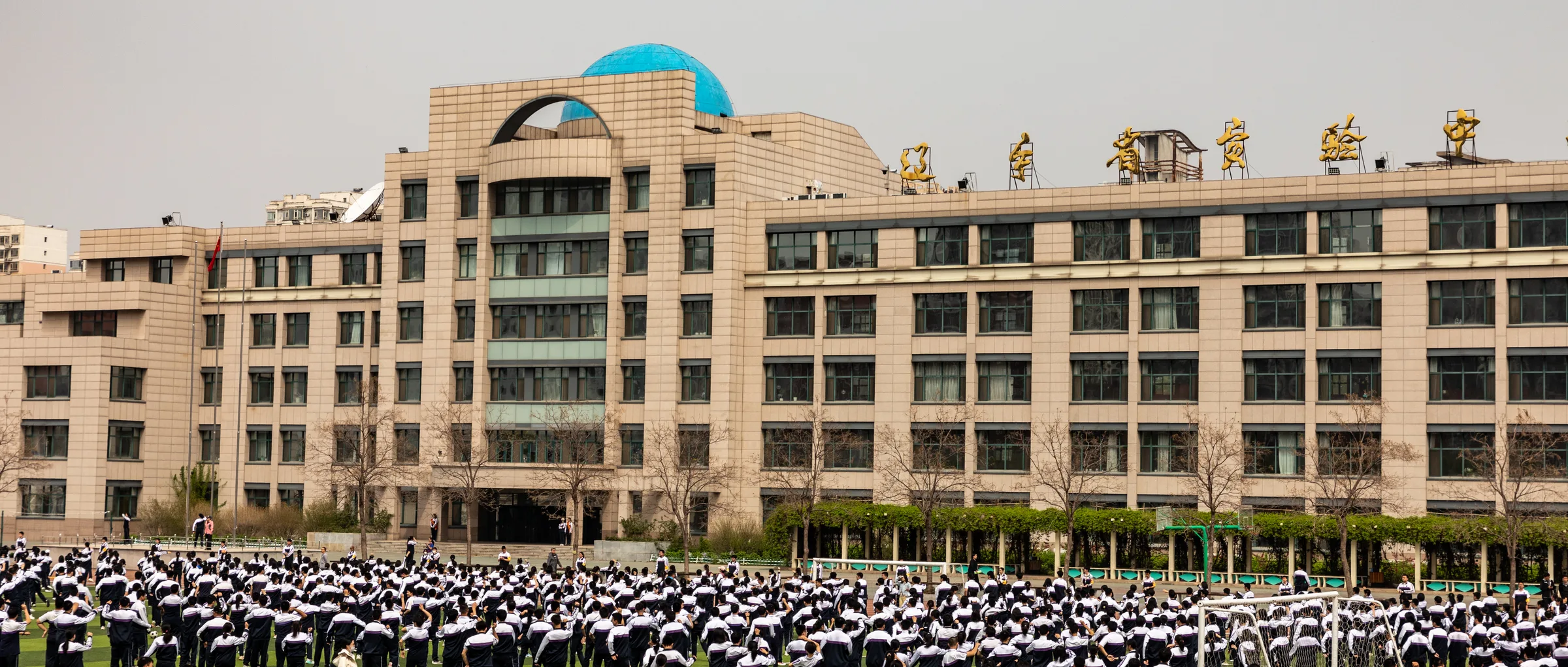 主教学楼全景，楼前空地上做操的同学们整齐排开