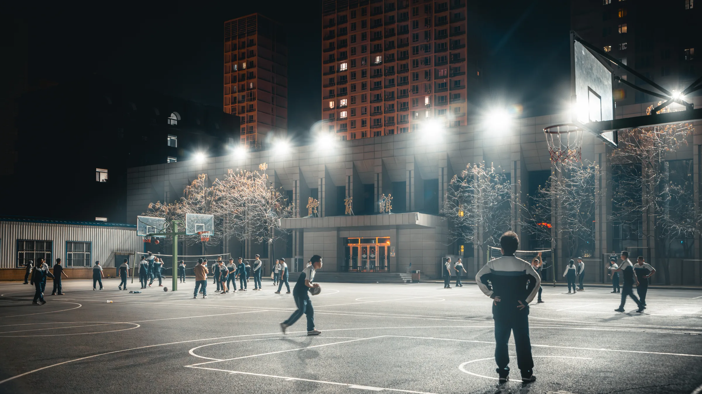 夜晚操场上还有几个人在灯光下活动