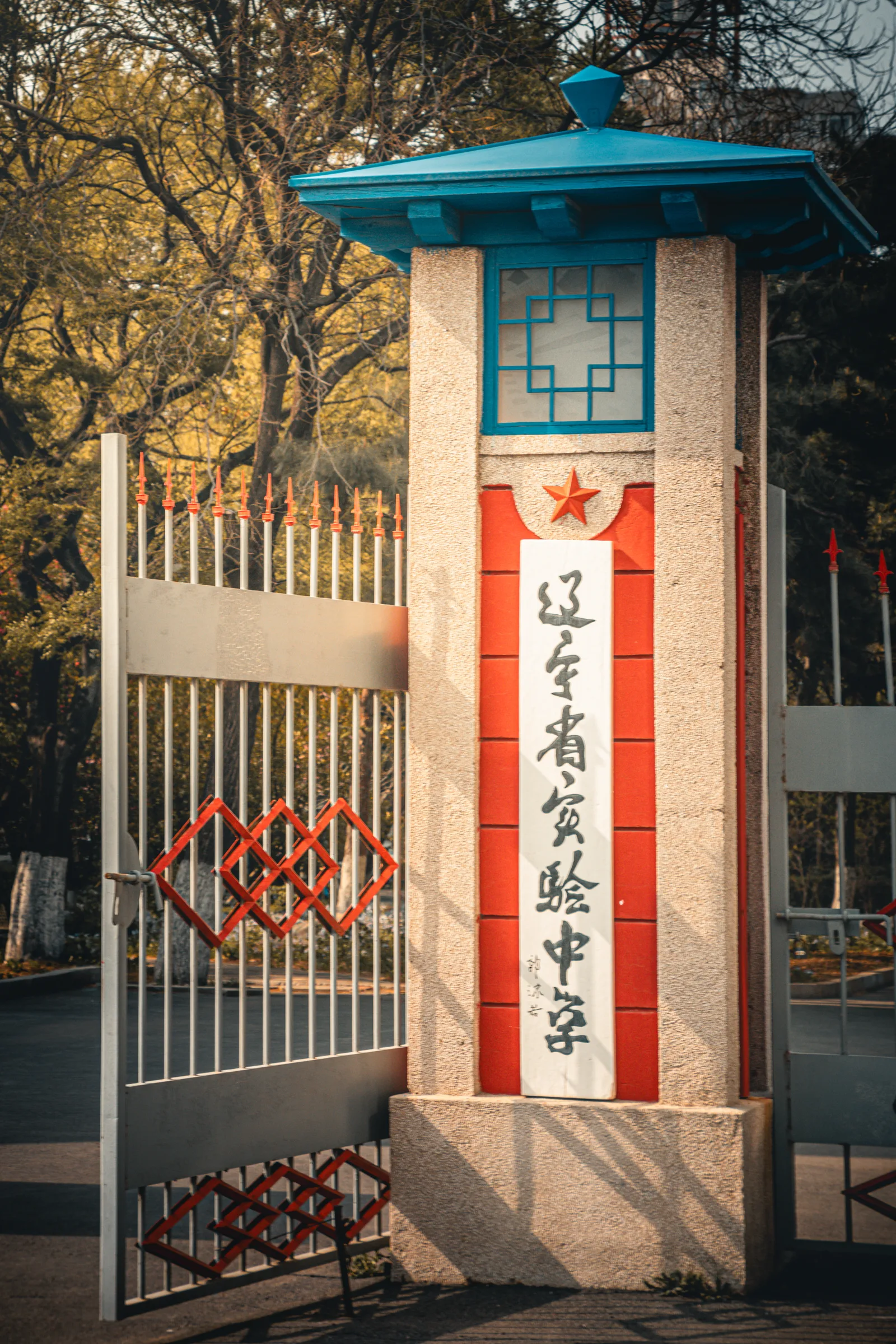 重建的辽宁省实验中学老校门立在春日树影前